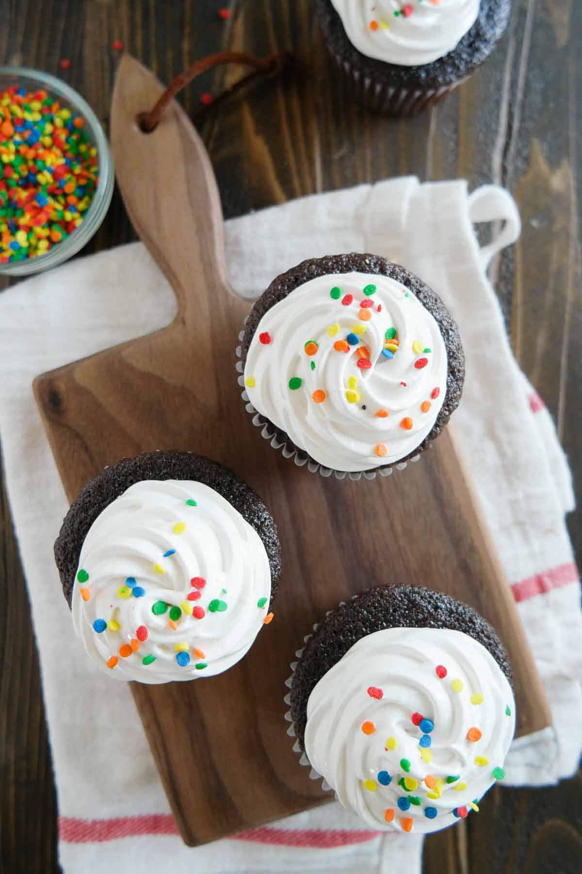 Top view of devil's food cupcakes topped with fluffy frosting.