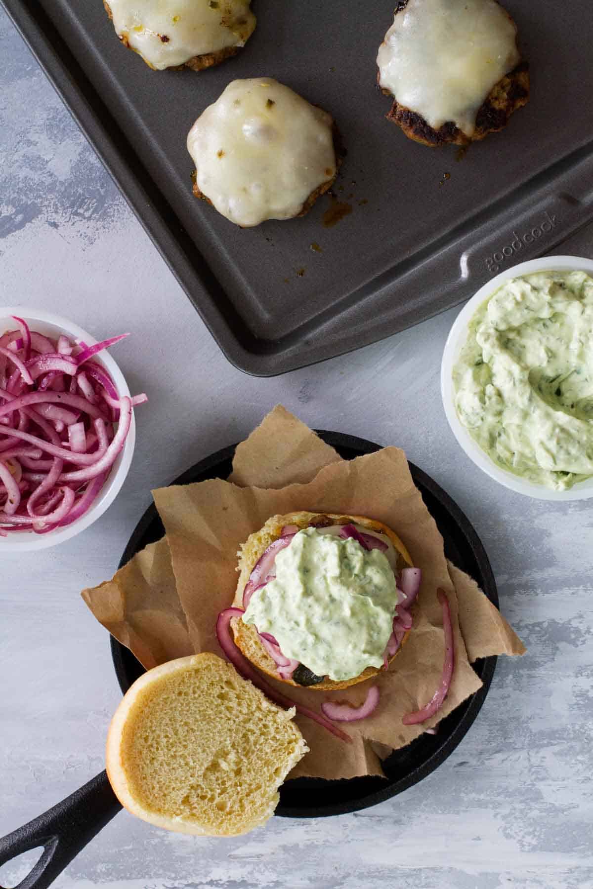 Slider burger topped with marinated red onions and creamy guacamole.