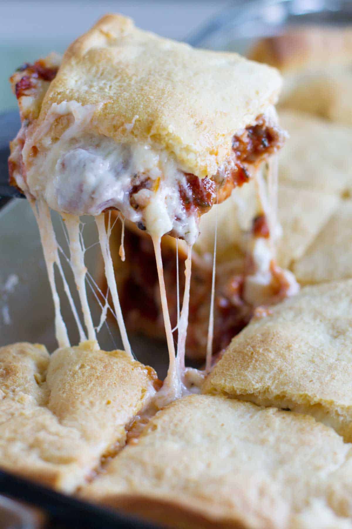 Scooping a slice of mock lasagna from a casserole dish.