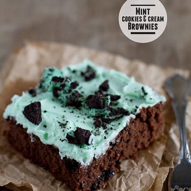 Mint cookies and cream brownies topped with cookie pieces.
