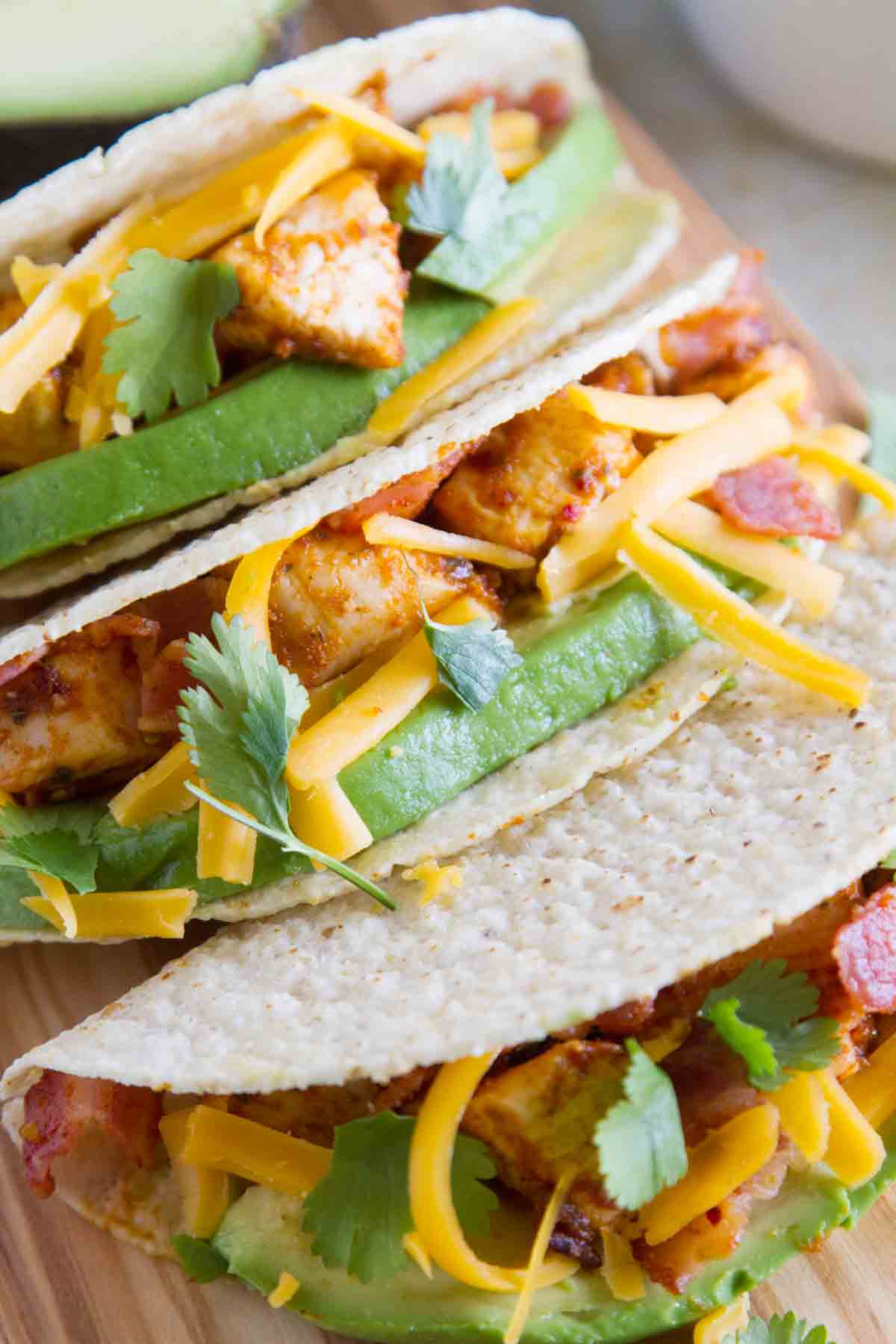 Close up of chicken bacon avocado tacos with hard taco shells.