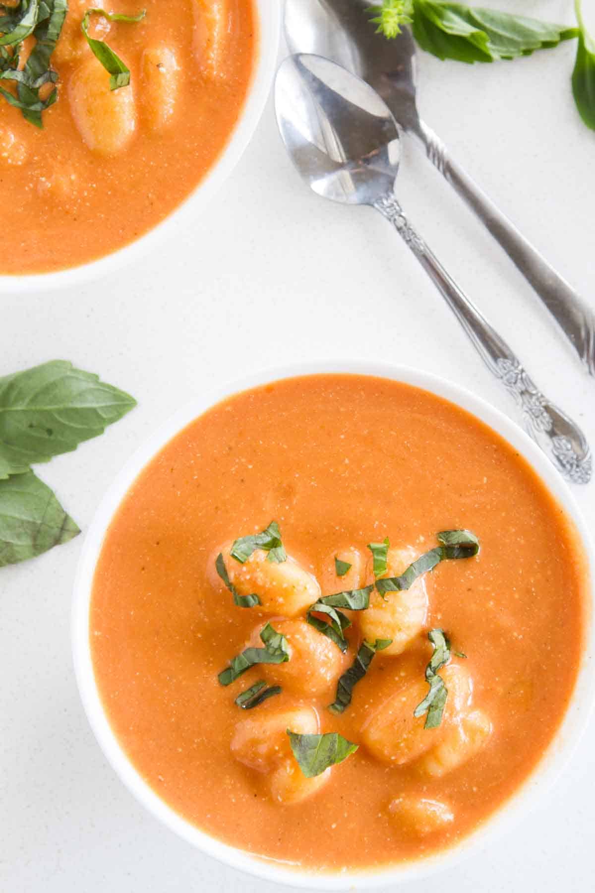 Bowl of Slow Cooker Tomato Soup with Gnocchi topped with fresh basil.