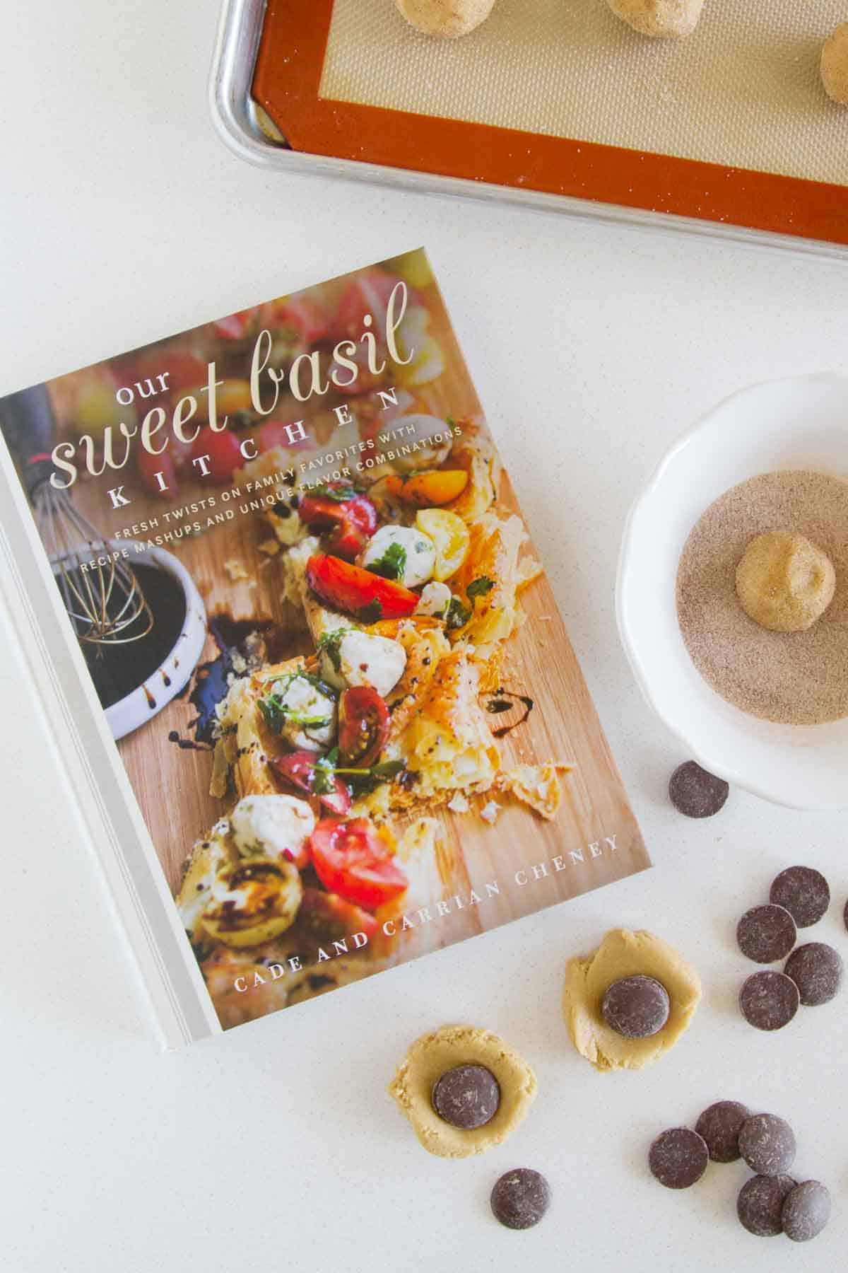 Our Sweet Basil Kitchen cookbook with ingredients surrounding it.