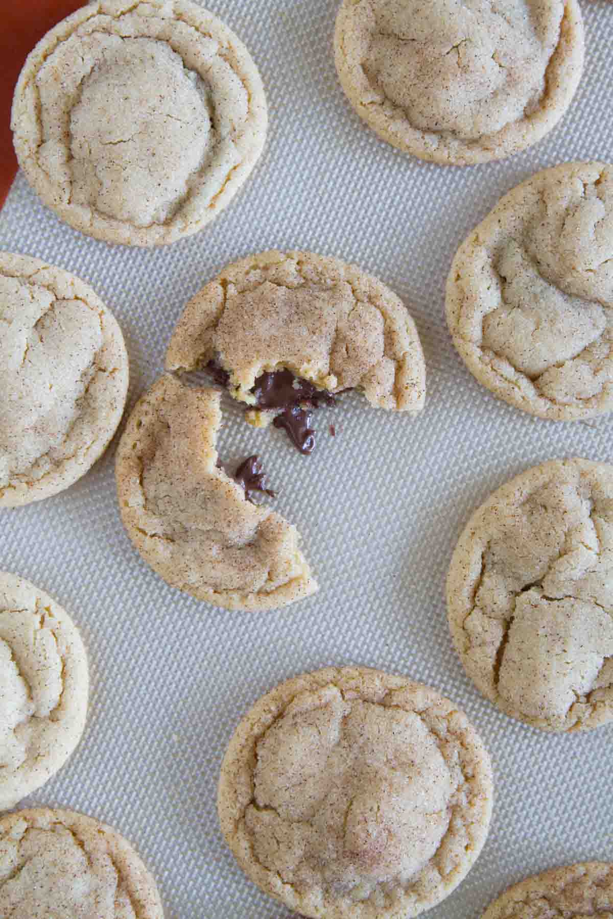 Peanut Butter Cinnamon Meltaway Cookies with one broken in half to show melting chocolate.