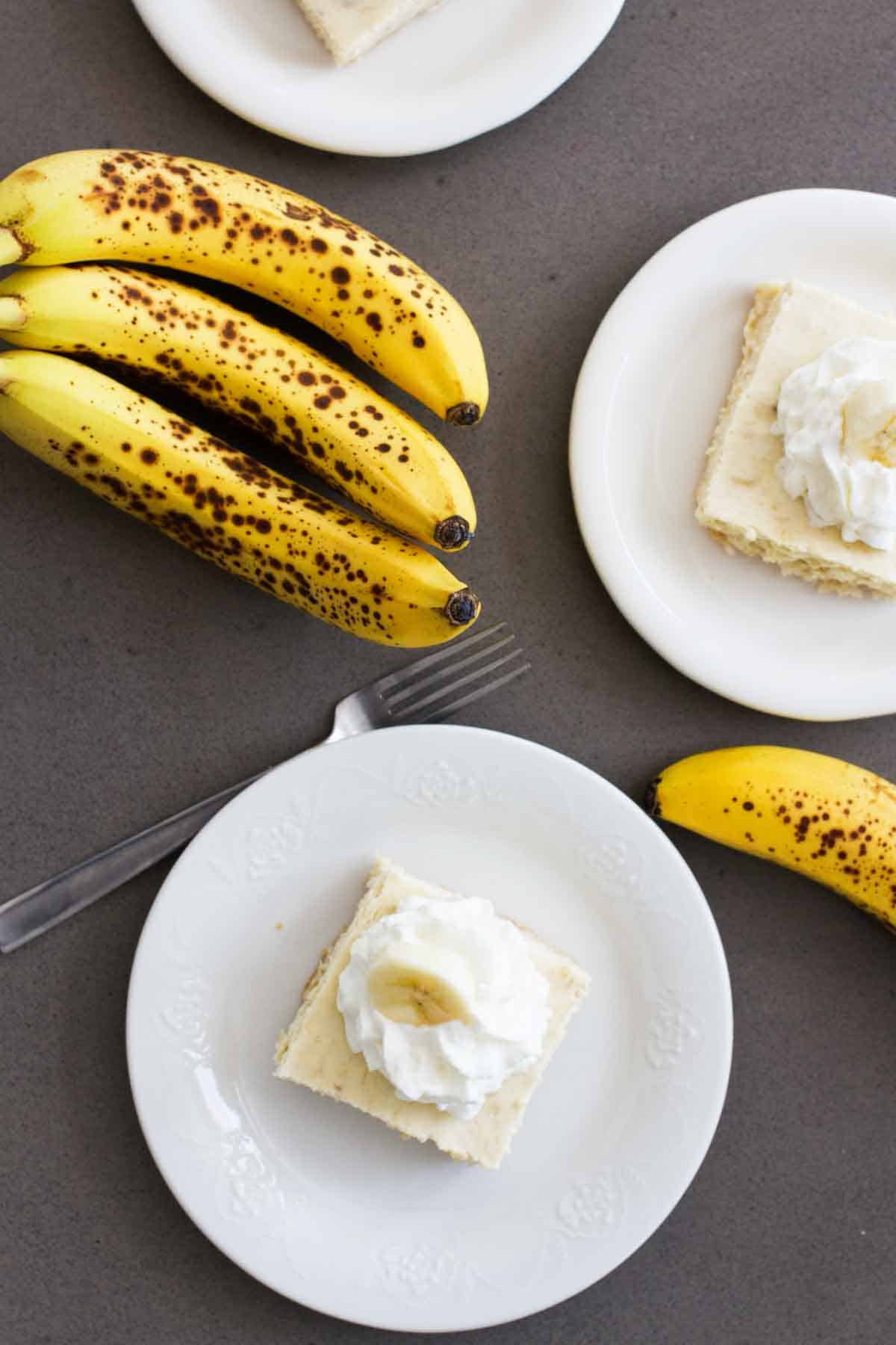 Three servings of banana cheesecake cookie bars on plates.