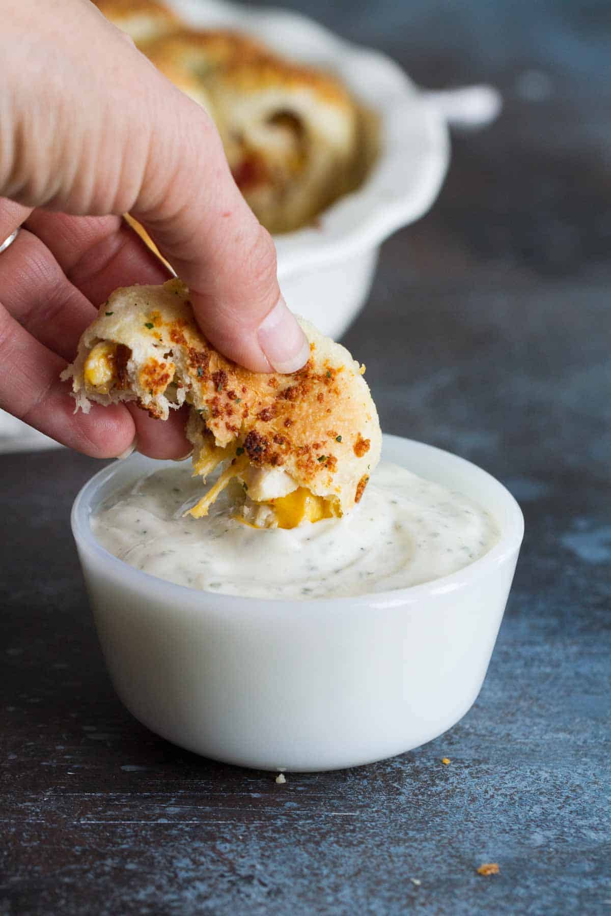 Dipping a stuffed pizza roll into ranch dressing.