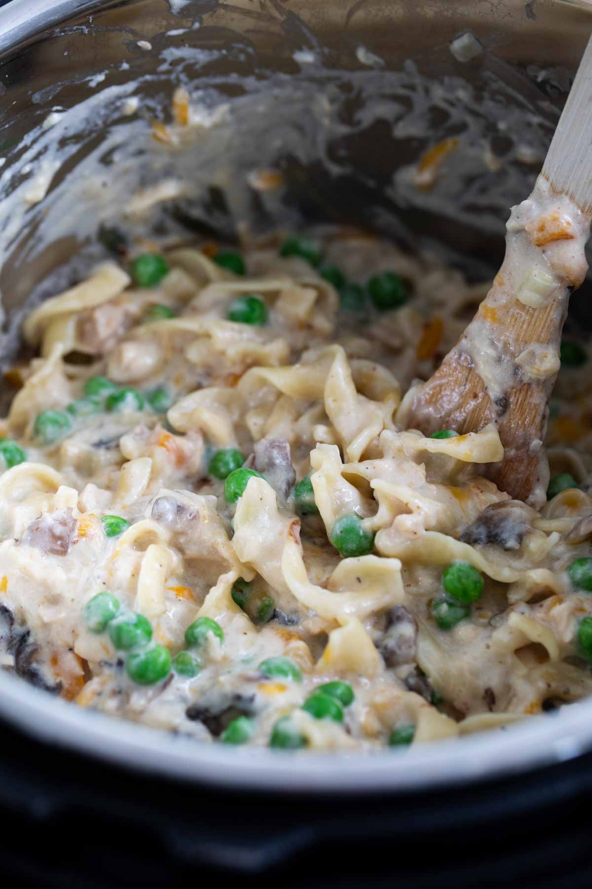 Homemade Tuna Noodle Casserole in an instant pot being stirred.