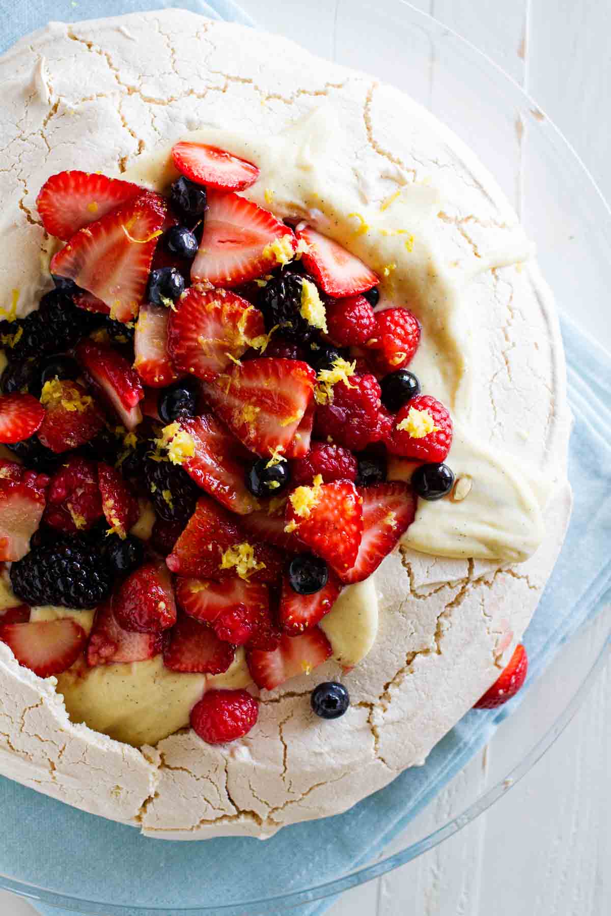 fresh berries with lemon zest on top of a pavlova