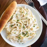 overhead view of Easy Alfredo Sauce and pasta on a plate with a breadstick