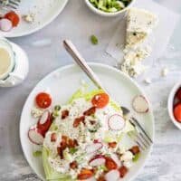 overhead view of wedge salad on plates with blue cheese and green onions