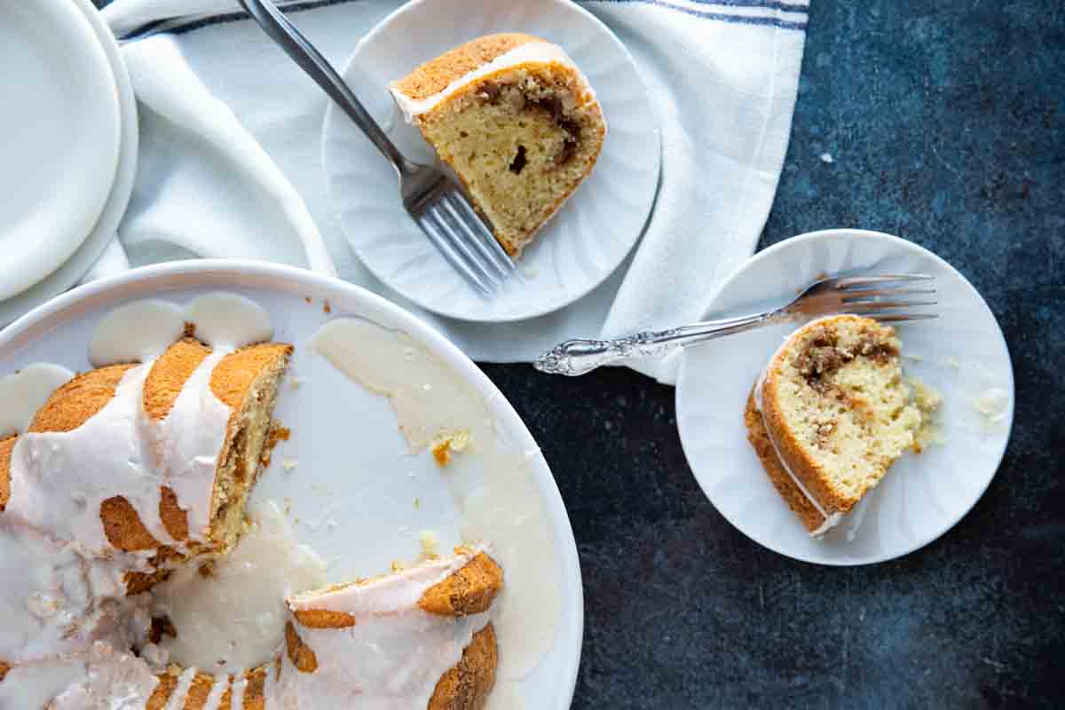 Two slices of sour cream coffee cake on plates with forks