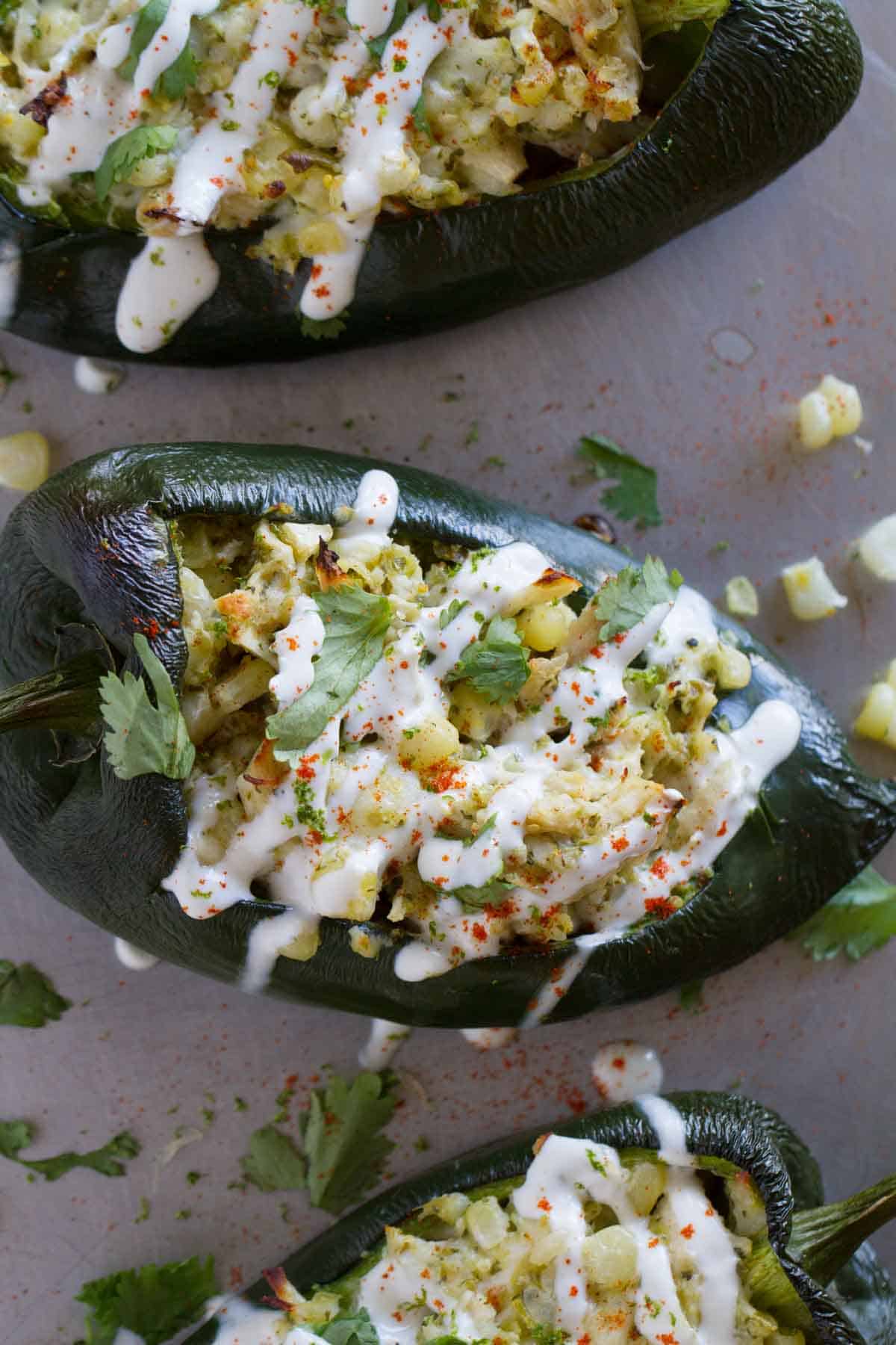 Poblano peppers stuffed with chicken and corn and topped with lime cream.