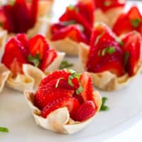 Strawberry Wonton Cups filled with cream cheese and topped with sliced strawberries.