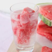 Glass filled with watermelon ice and sparkling water.