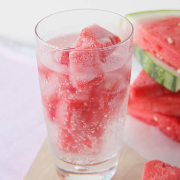 Glass filled with watermelon ice and sparkling water.