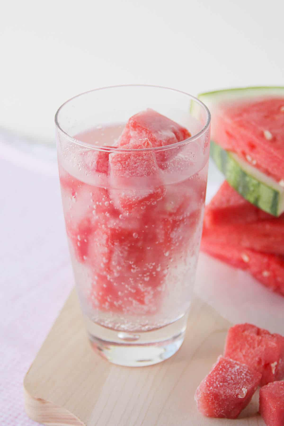 Glass filled with watermelon ice and sparkling water.