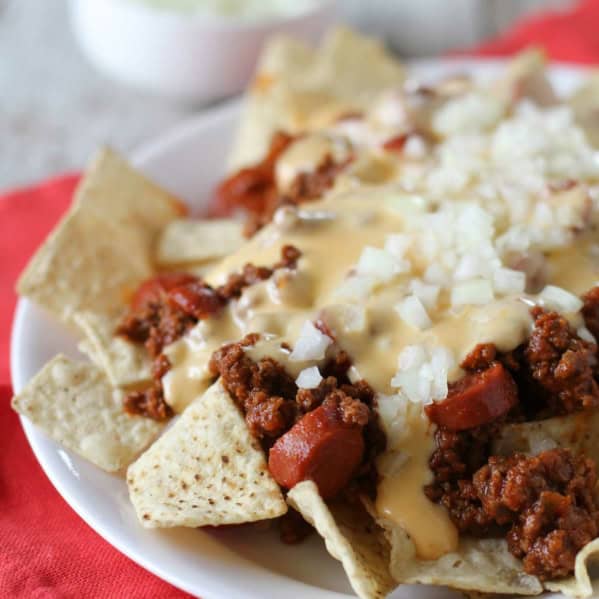 Chili Dog Nachos topped with hot dog filled chili and cheese sauce.