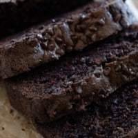 Slices of chocolate zucchini bread topped with mini chocolate chips.