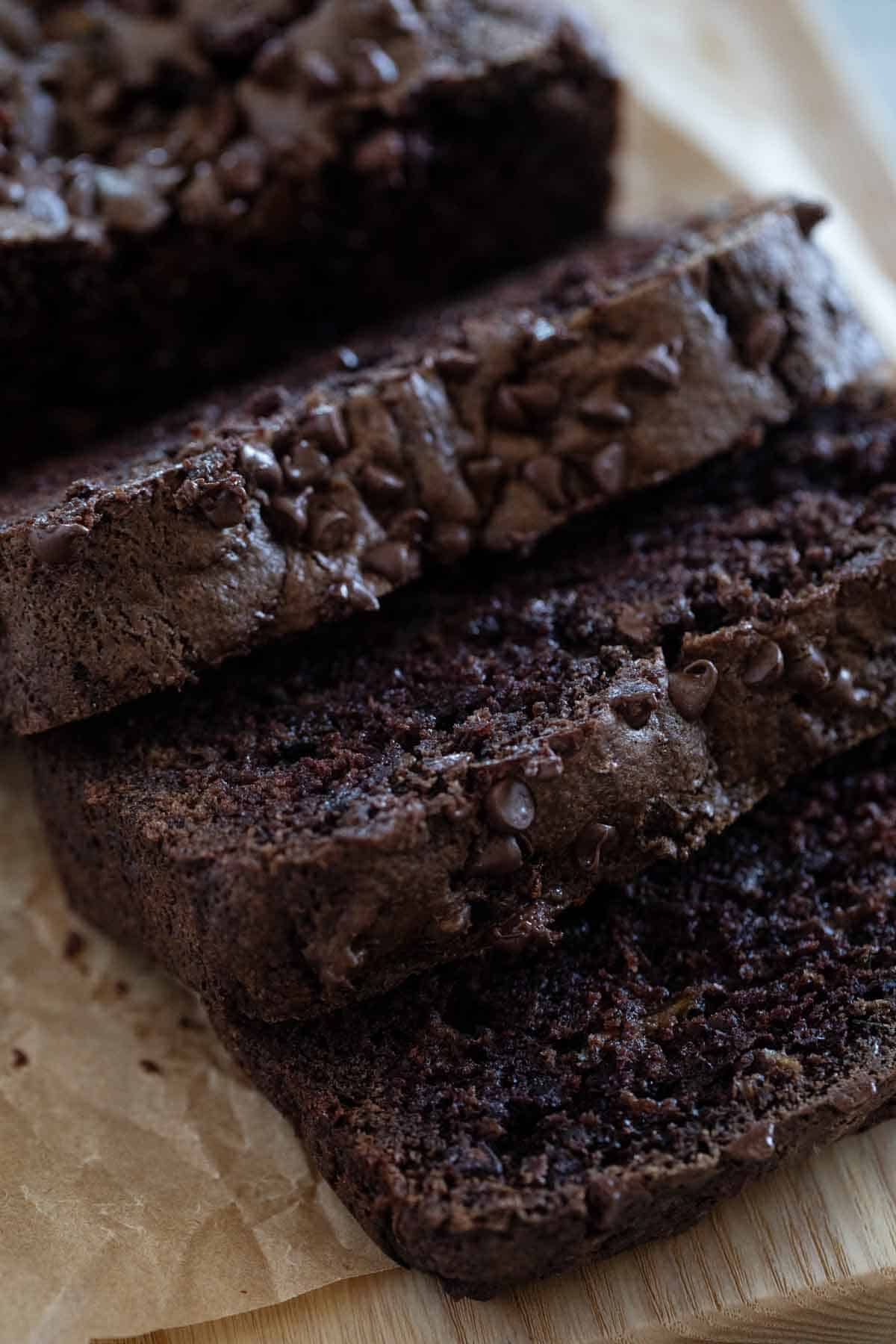 Slices of chocolate zucchini bread topped with mini chocolate chips.