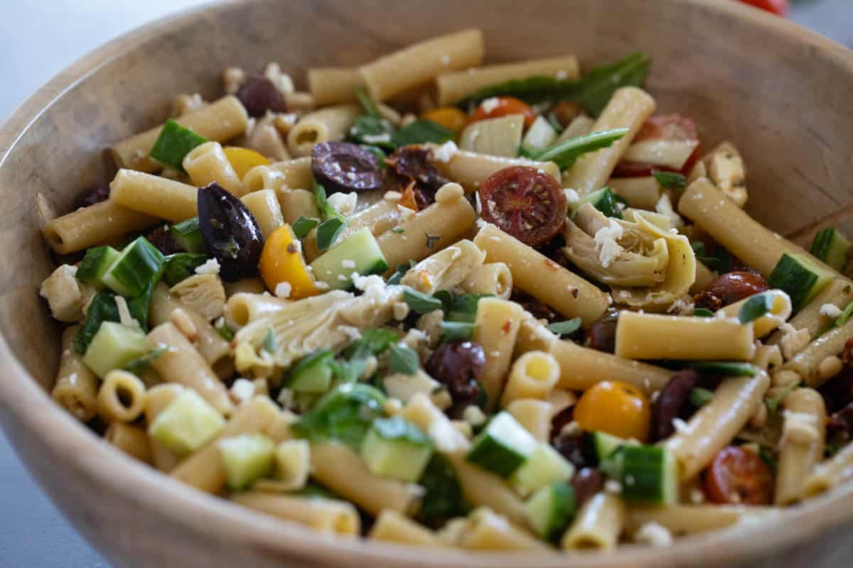 Wooden bowl filled with Mediterranean Pasta Salad.