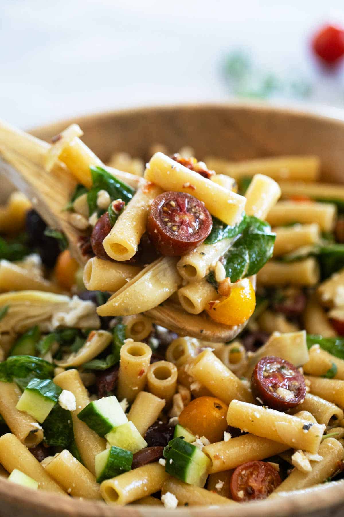 Wooden spoon full of Mediterranean Pasta Salad.