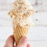 Ice cream cone with salted caramel ice cream with fudge and toasted coconut.