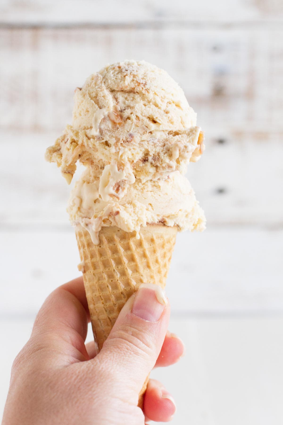 Ice cream cone with salted caramel ice cream with fudge and toasted coconut.
