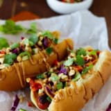 Two Thai Style Hot Dogs topped with peanut sauce.