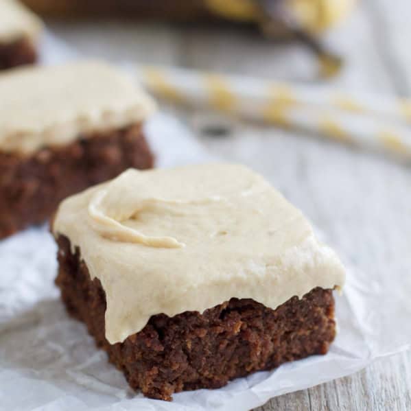 Banana Brownie topped with peanut butter banana frosting on parchment.