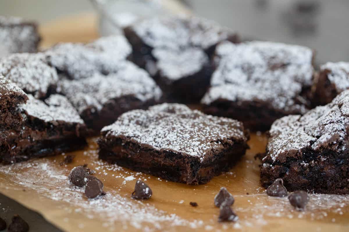 Cake mix brownies sprinkled with powdered sugar on a piece of parchment paper.