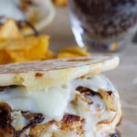 Chicken and Chorizo Patty Melts on flat bread with onions and cheese.