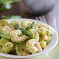 Gnocchi with pesto, served with shrimp and asparagus.