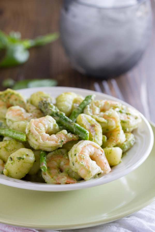 Gnocchi with pesto, served with shrimp and asparagus.