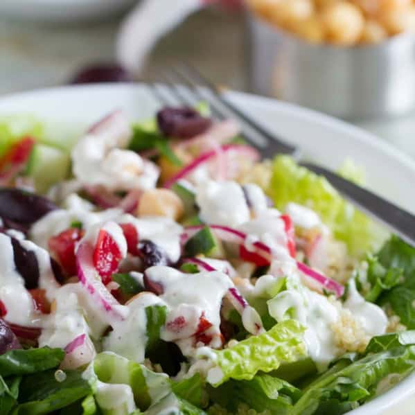 Bowl filled with Greek Quinoa Salad with homemade dressing.