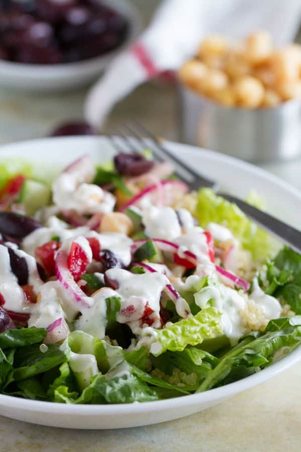 Bowl filled with Greek Quinoa Salad with homemade dressing.