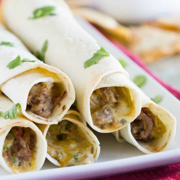 5 Mexican Shredded Beef Baked Taquitos stacked on top of each other.