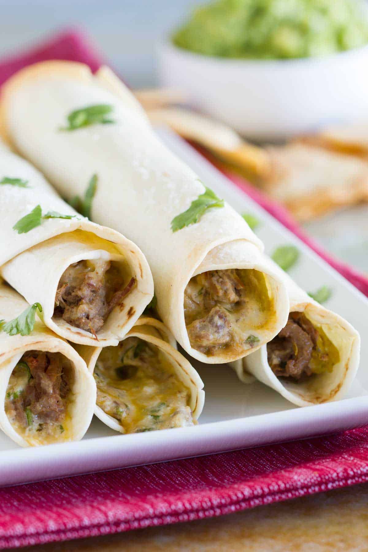 5 Mexican Shredded Beef Baked Taquitos stacked on top of each other.