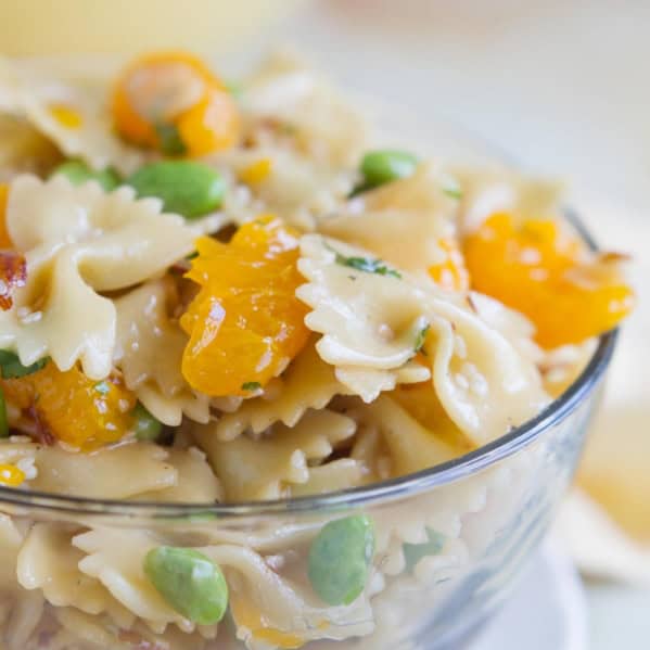 Oriental Pasta Salad with pasta, mandarin oranges, and edamame in a large glass bowl.