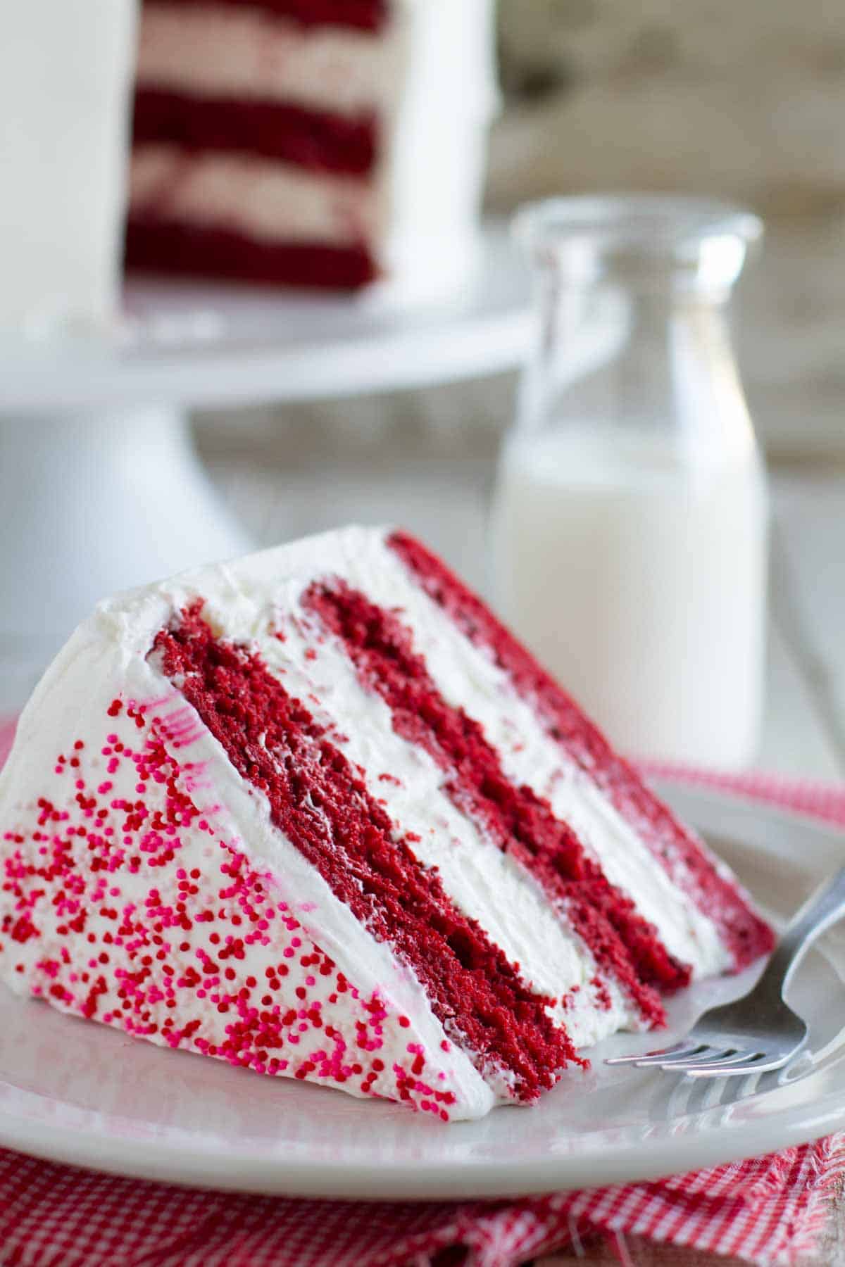 Slice of Red Velvet Ice Cream Cake with layers of red velvet cake and cheesecake ice cream.