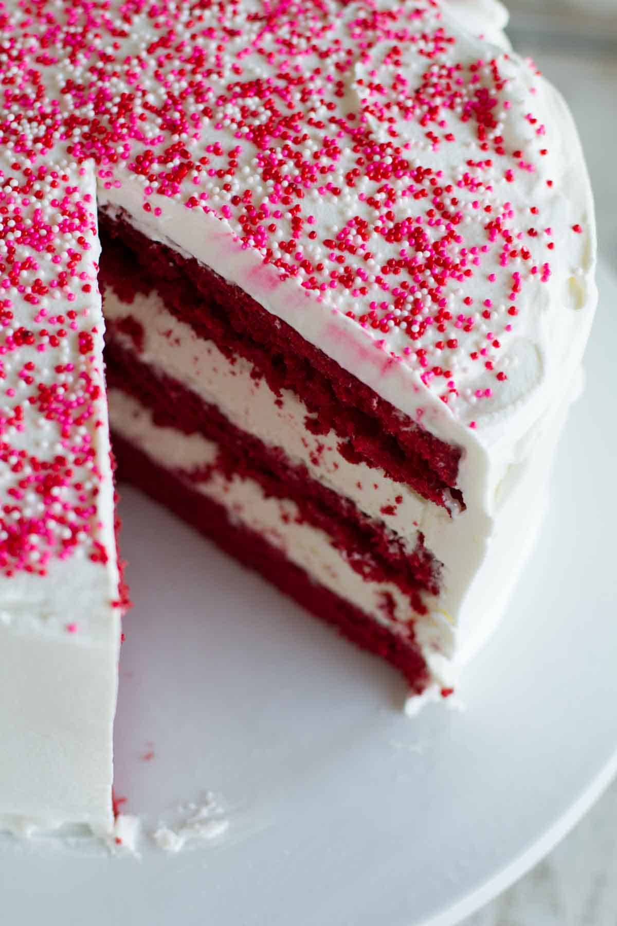 Red Velvet Ice Cream Cake with a slice taken from it.