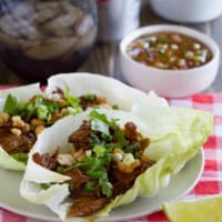 2 BBQ Pork Lettuce Wraps on a plate on top of a checkered cloth.