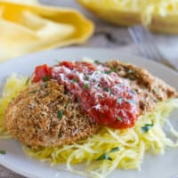 Baked Chicken Parmesan with tomato sauce and herbs.