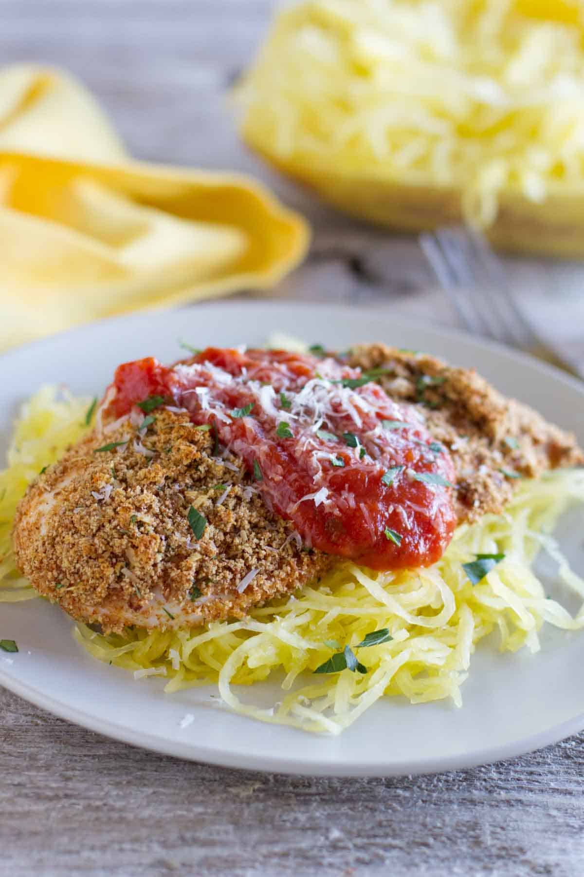 Baked Chicken Parmesan with tomato sauce and herbs.