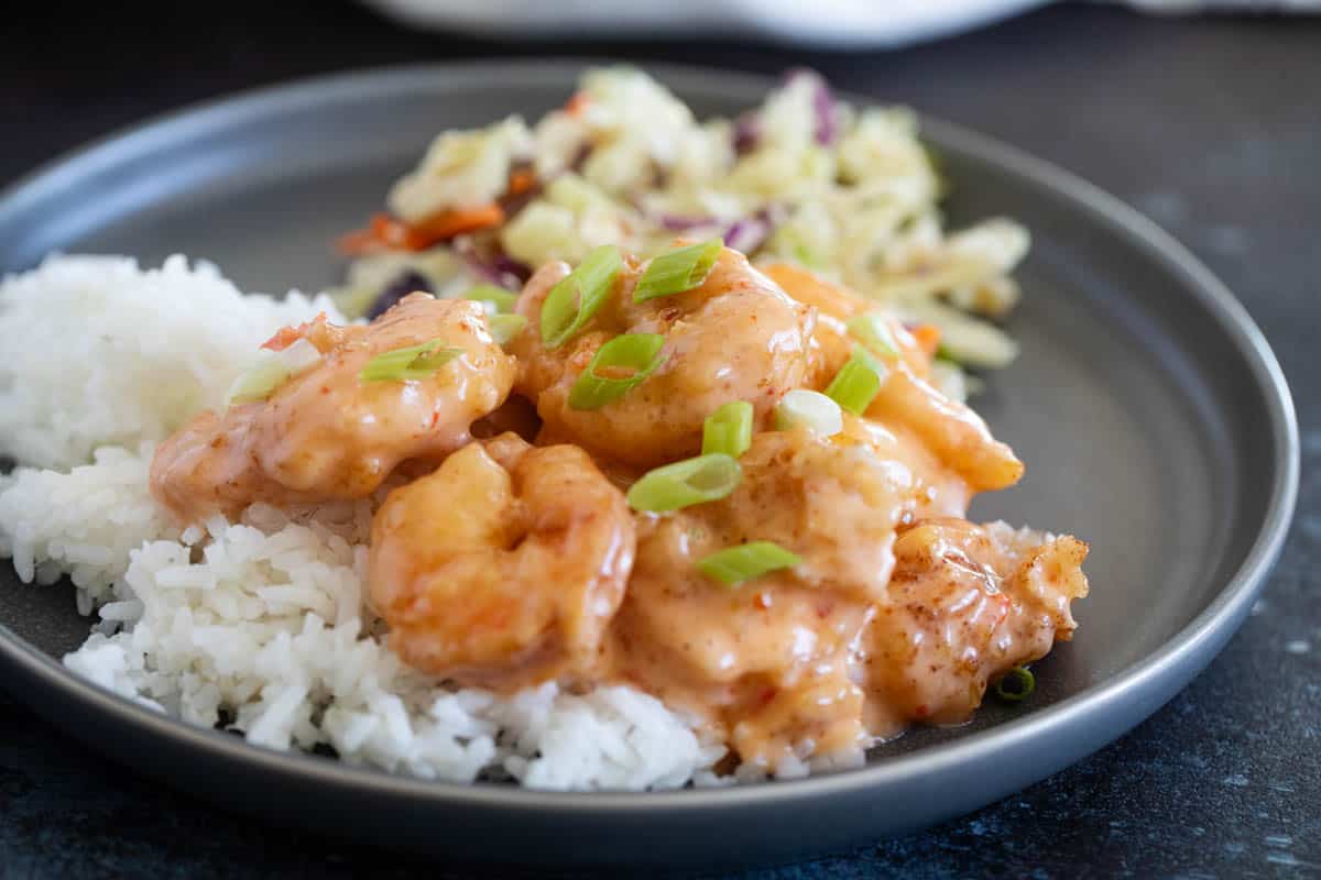 Bang Bang Shrimp served over rice and topped with green onions.