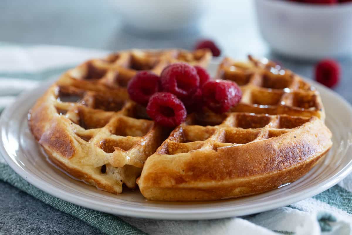 Belgian Waffle Recipe - topped with syrup and raspberries.