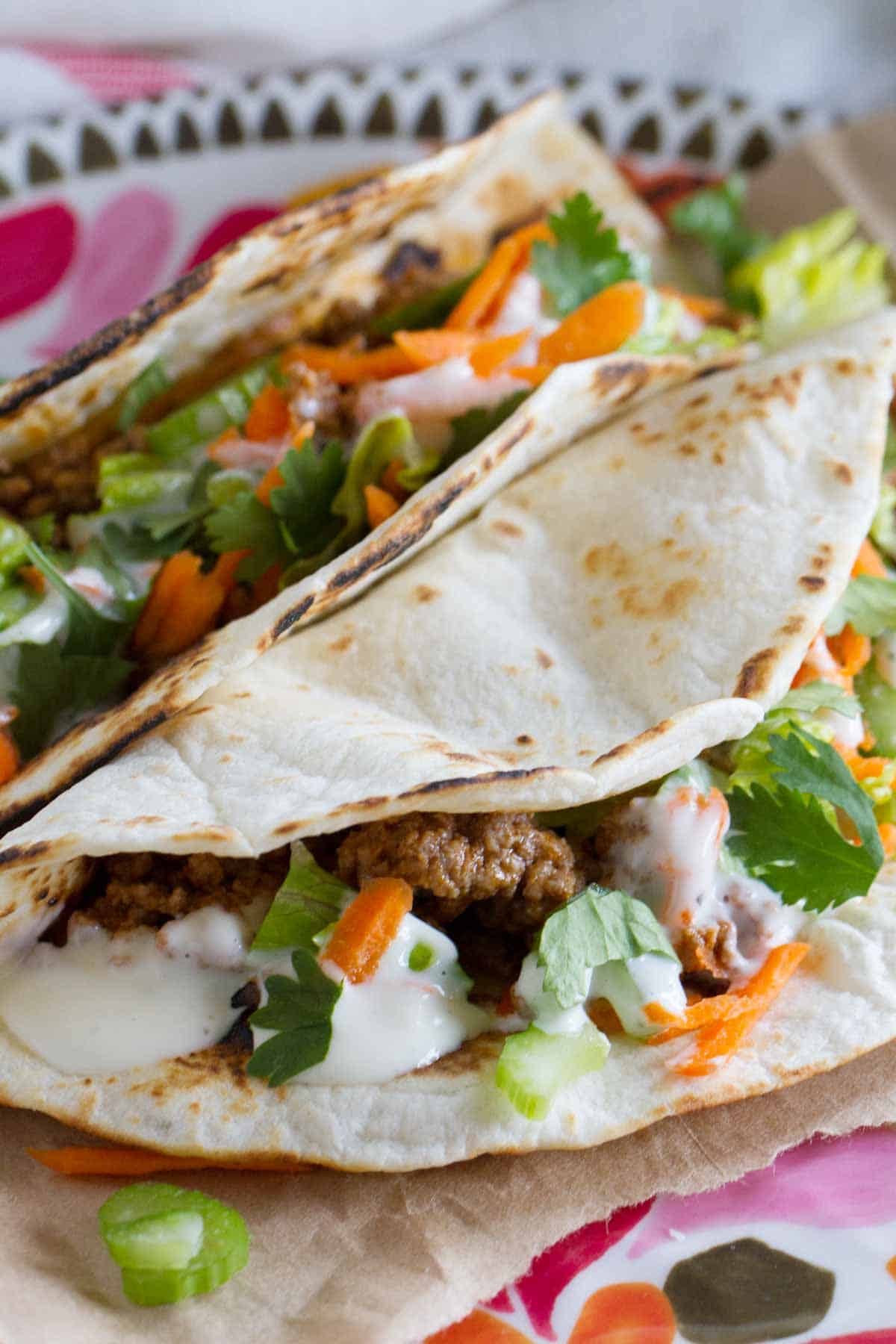 Two buffalo beef tacos with blue cheese dressing.