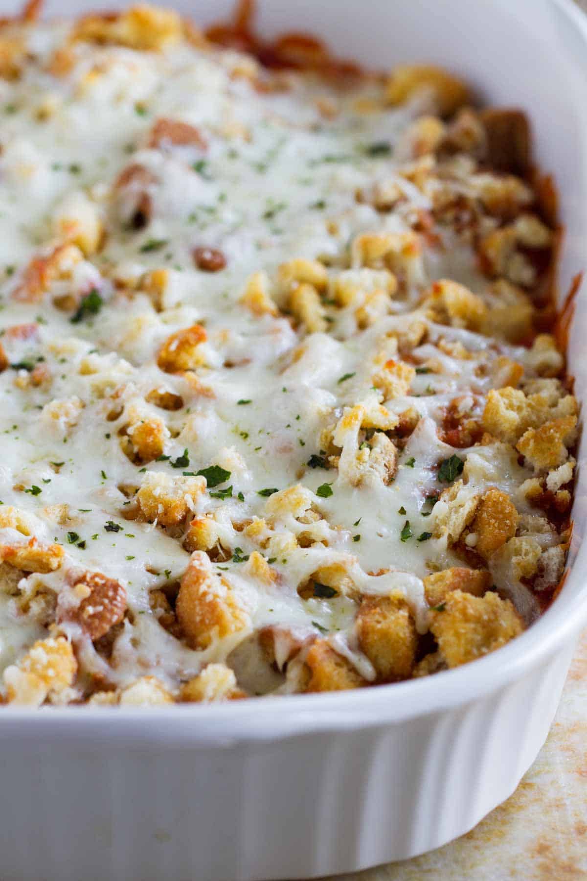 Chicken Parmesan Casserole in a white casserole dish, topped with melted cheese.