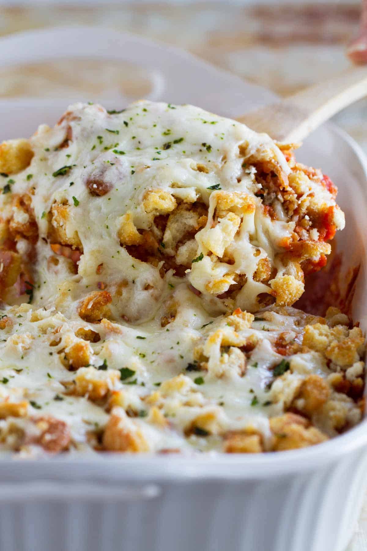 Scooping out a serving of chicken parmesan casserole.