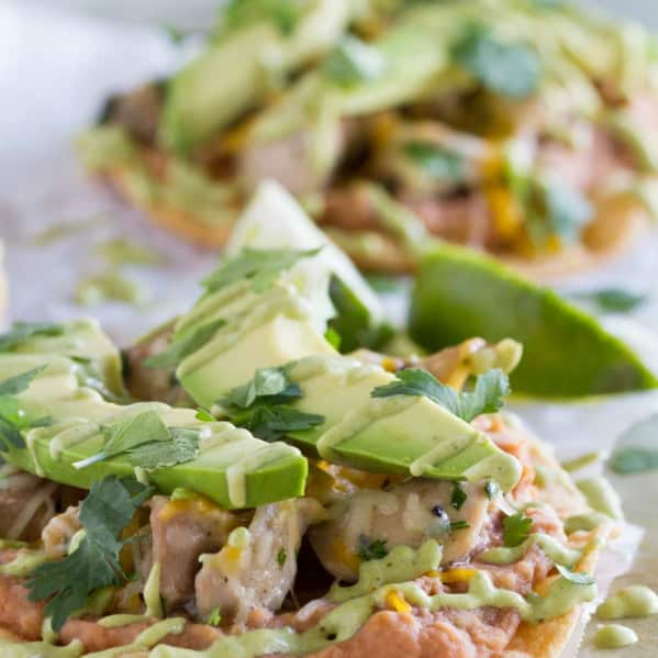 Chicken Tostadas with Poblano Cream Sauce, topped with avocado and cilantro.