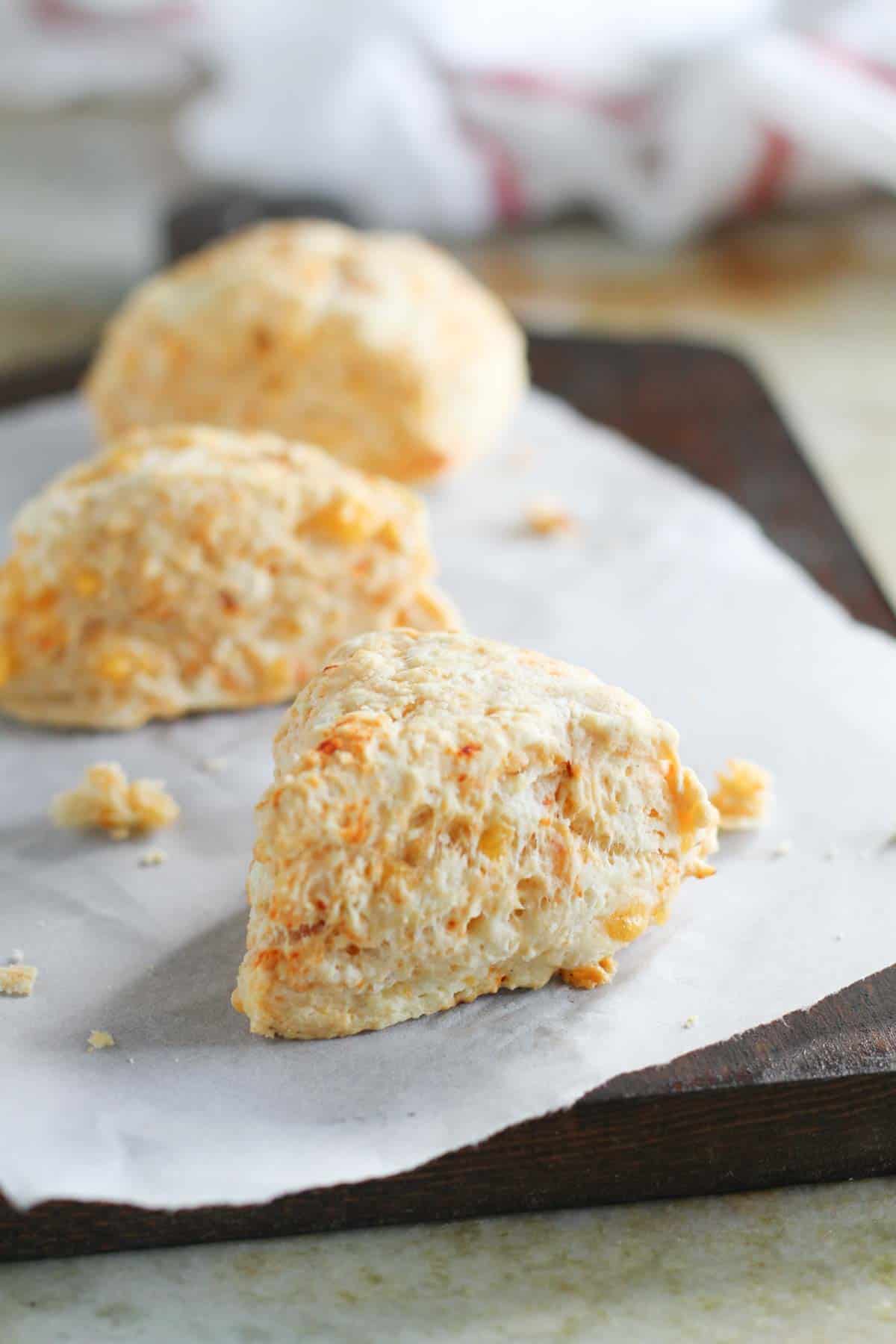 Chipotle Cheddar Scones on a cutting board with parchment paper.